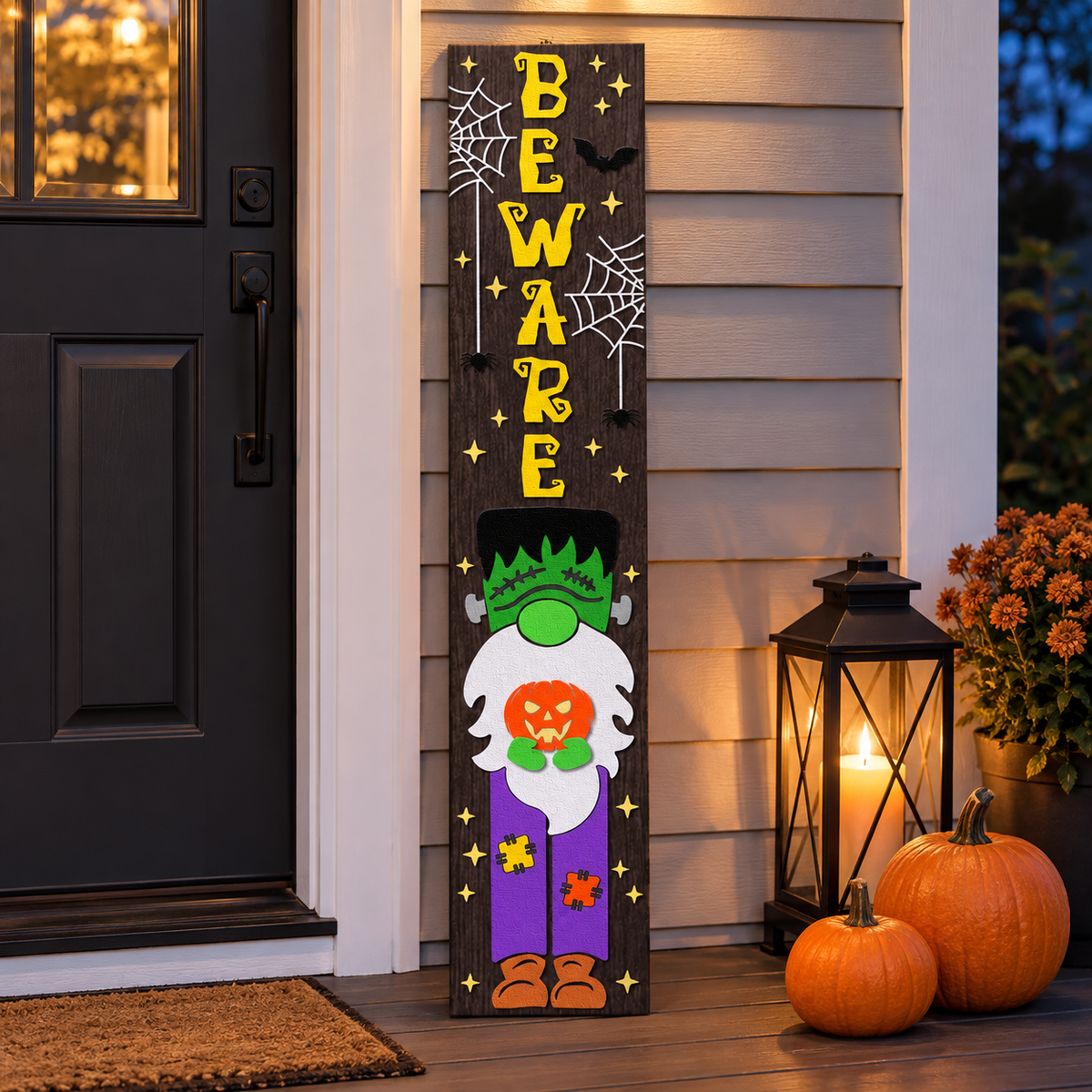 Layered wood Halloween porch leaner glowing at dusk beside a lantern and pumpkins